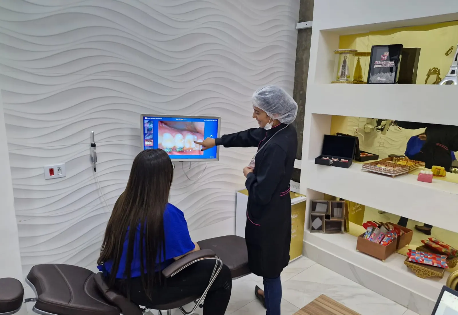 Dentista da Nova Perolla Odontologia mostrando a imagem dos dentes à paciente